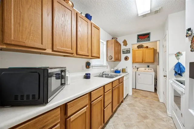 a kitchen with granite countertop a sink stove and cabinets