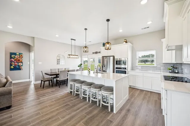 a large kitchen with a table and chairs