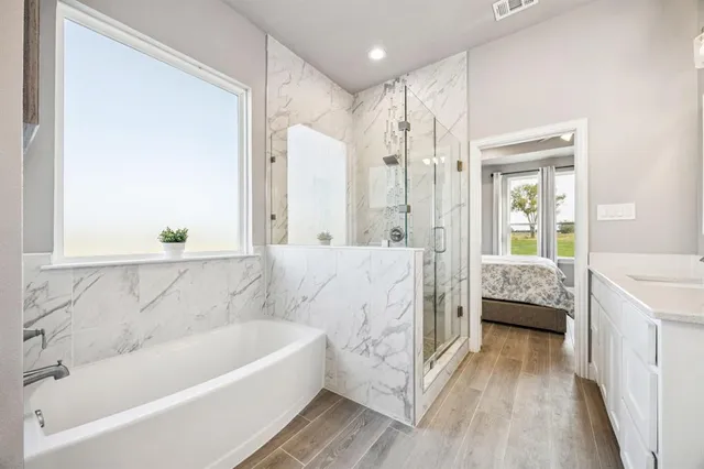 a bathroom with a double vanity sink mirror and bathtub