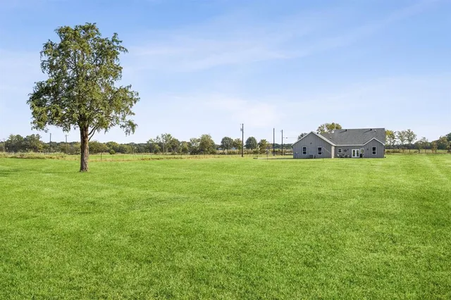 a view of a patio with table and chairs and potted plants with wooden floor and fence
