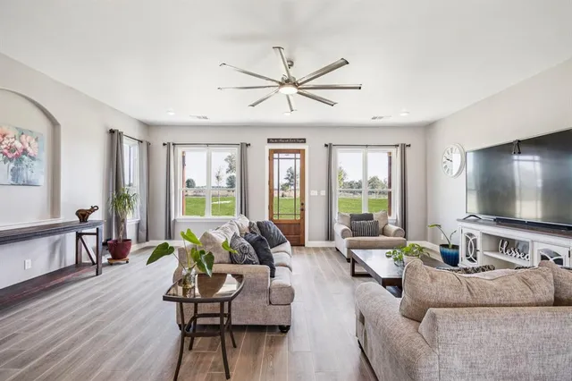 a living room with furniture and a flat screen tv with wooden floor
