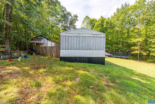 a view of backyard with wooden fence and trees