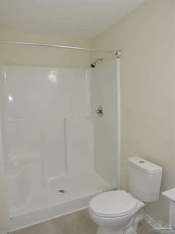 a white toilet sitting next to a bath tub