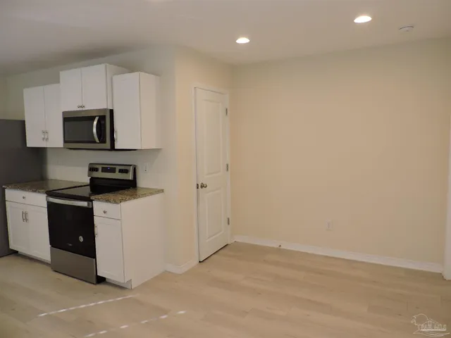 a kitchen with a sink a microwave and cabinets