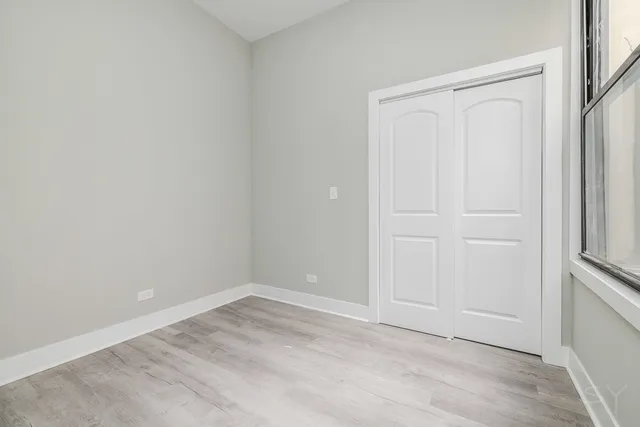 an empty room with windows and closet