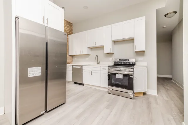 a kitchen with stainless steel appliances a refrigerator sink and stove