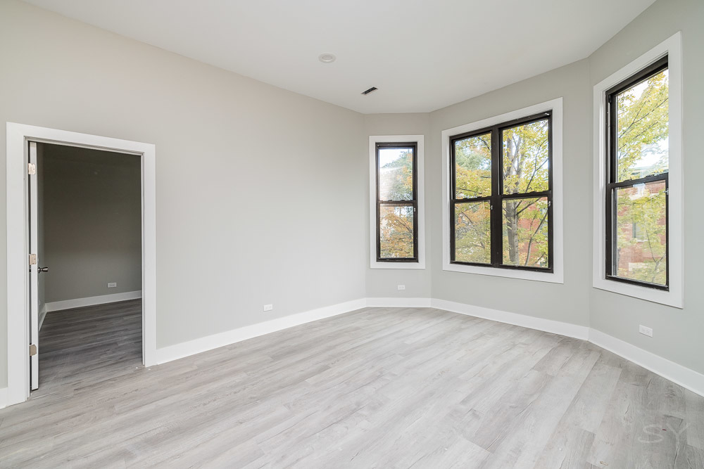 2448 South Oakley Avenue, Unit 2F Chicago, IL 60608 - Photo 6 of 14 an empty room with wooden floor and windows
