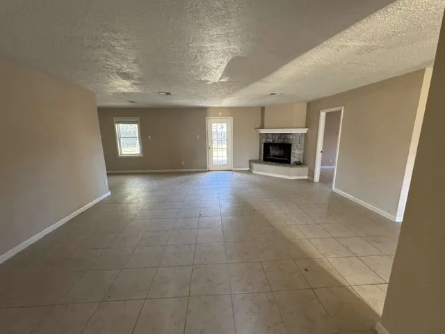 a view of a livingroom with a fireplace and window
