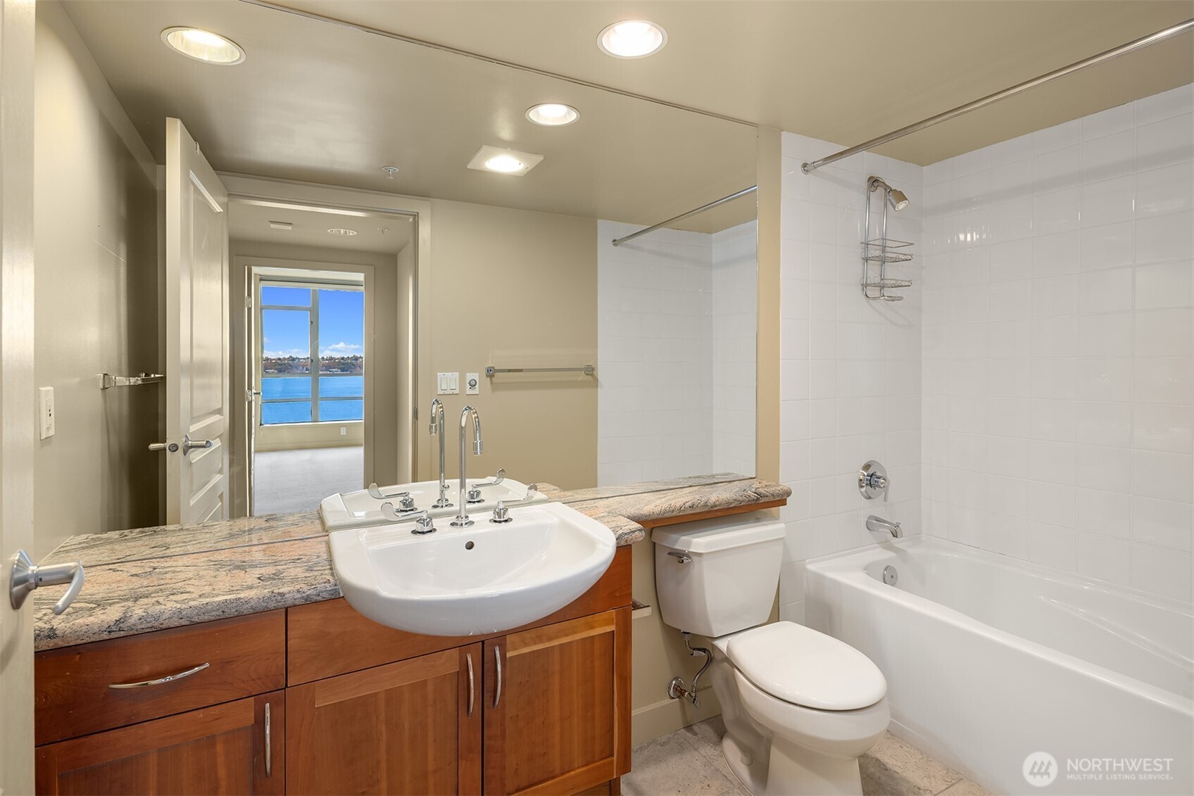 2929 1st Avenue, Unit 1200 Seattle, WA 98121 - Photo 13 of 23 a bathroom with a granite countertop sink toilet mirror and shower