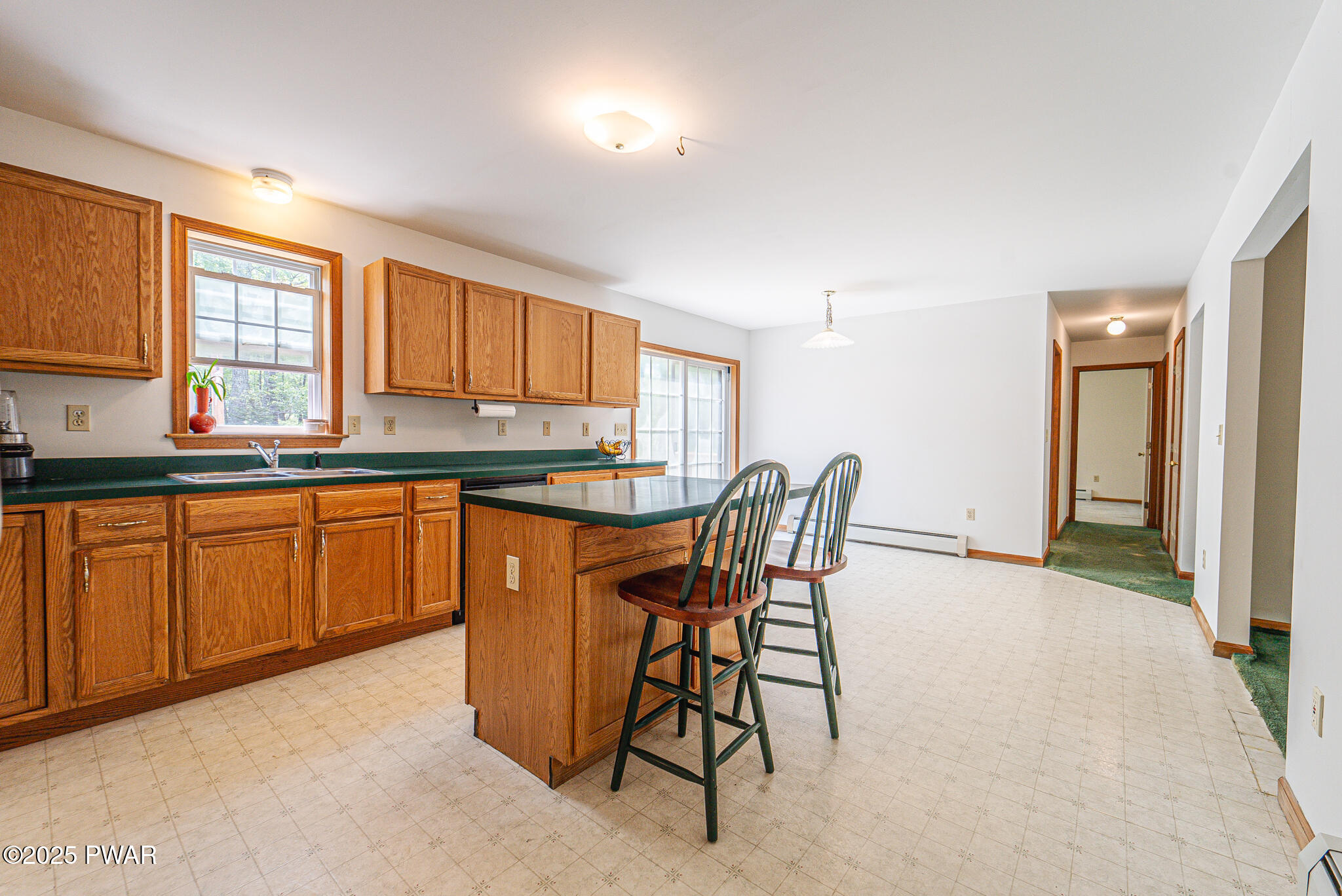 101 Maple Ridge Road Milford, PA 18337 - Photo 15 of 39 a kitchen with stainless steel appliances granite countertop a stove a sink dishwasher a dining table and chairs with wooden floor