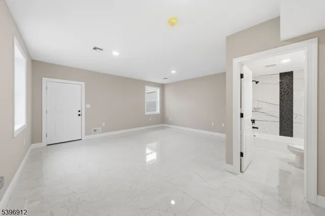 an empty room with window and wooden floor