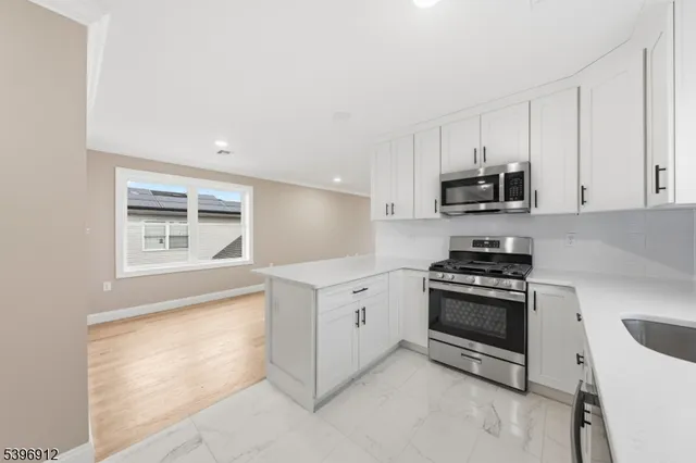 a kitchen with stainless steel appliances a stove a sink and a microwave