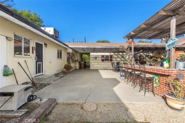 a view of a patio with table and chairs under an umbrella