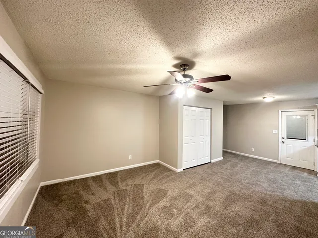 a view of an empty room with a chandelier fan