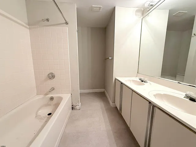 a bathroom with a tub sink and mirror