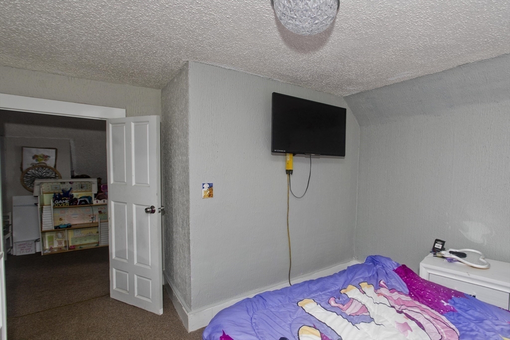 52 Orlando Street Springfield, MA 01108 - Photo 11 of 29 a bedroom with a bed and a flat tv screen