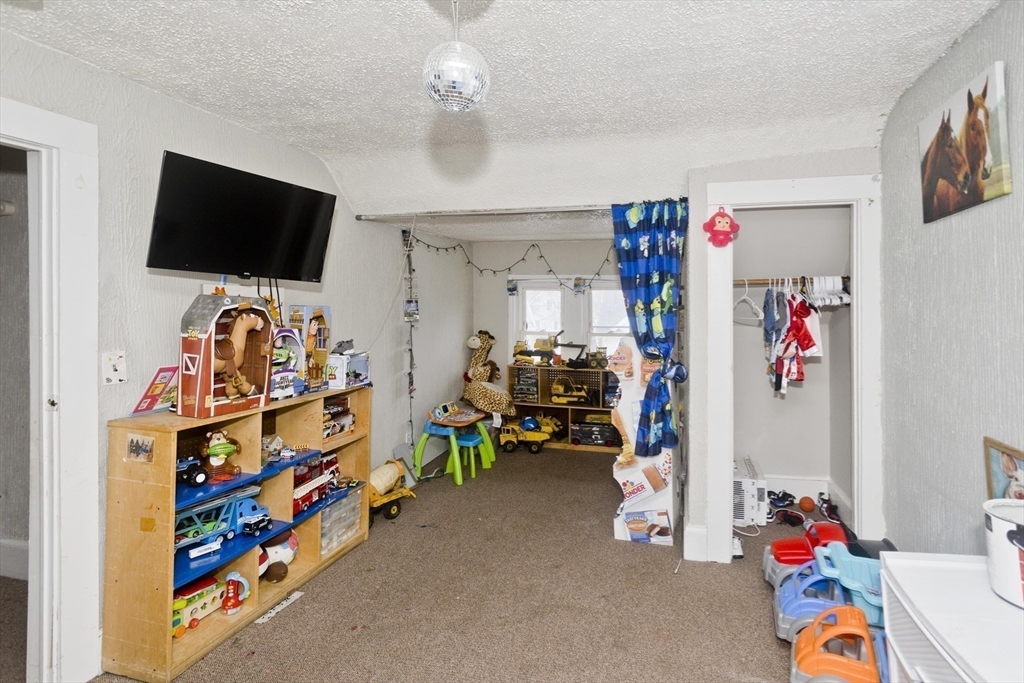52 Orlando Street Springfield, MA 01108 - Photo 12 of 29 a children room with toys and a flat screen tv