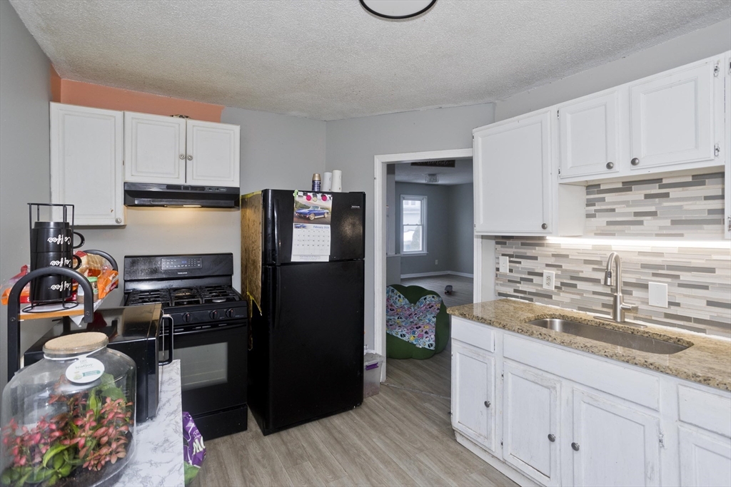 52 Orlando Street Springfield, MA 01108 - Photo 6 of 29 a kitchen with kitchen island granite countertop a sink cabinets and stainless steel appliances