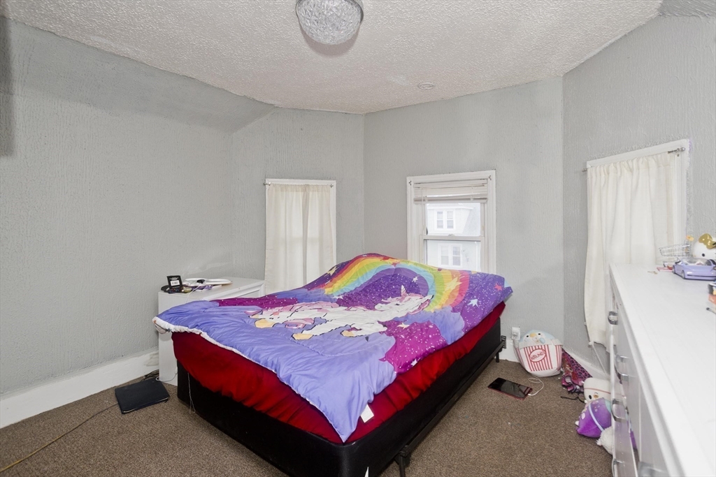 52 Orlando Street Springfield, MA 01108 - Photo 10 of 29 a bed sitting in a bedroom next to a window