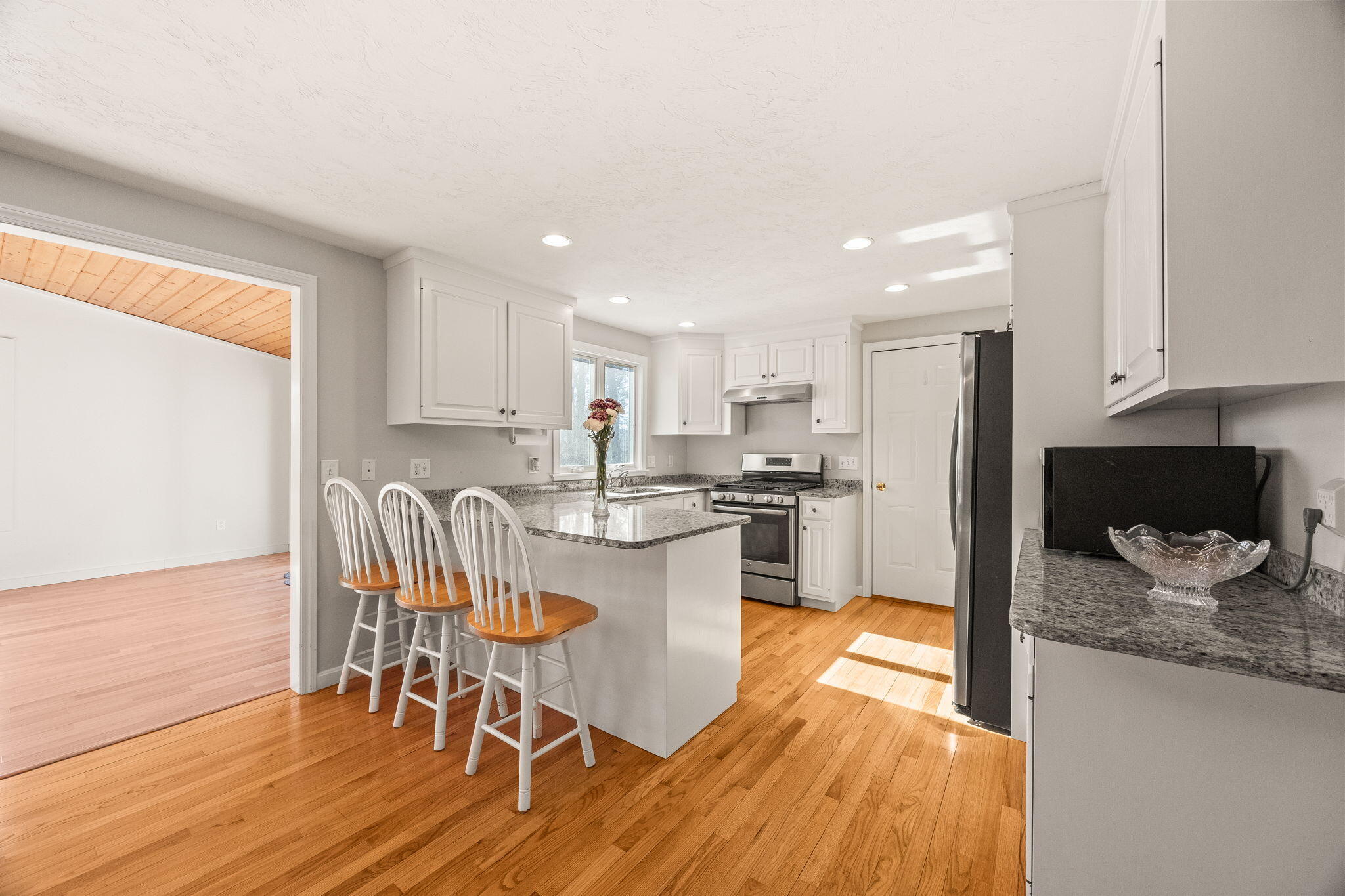 84 Middle Road South Chatham, MA 02659 - Photo 8 of 48 a kitchen with stainless steel appliances granite countertop a refrigerator a stove top oven and a dining table with wooden floor