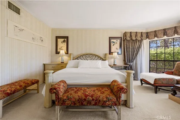 a spacious bedroom with a bed and a chandelier
