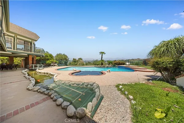an aerial view of a house with a swimming pool and garden