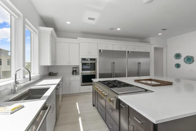 a living room with lots of furniture and a dining table with kitchen view
