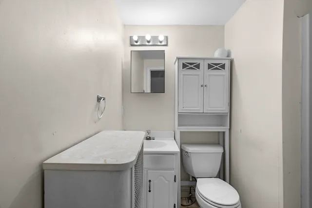 a bathroom with a toilet sink and mirror