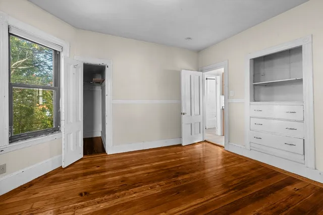 a view of a room with wooden floor and cabinet