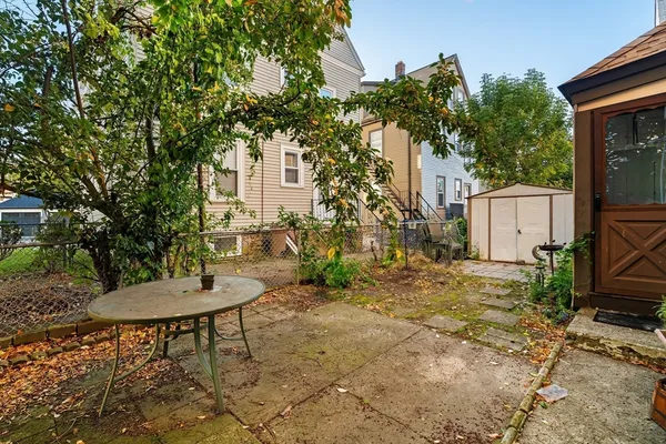 a backyard of a house with table and chairs