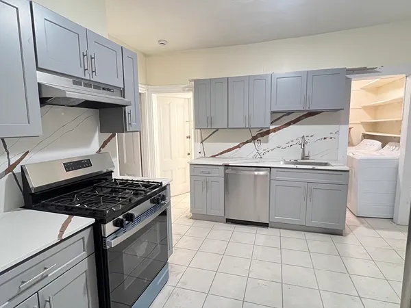 a kitchen with a stove a sink and cabinets