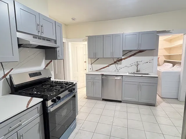 a kitchen with a stove a sink and cabinets