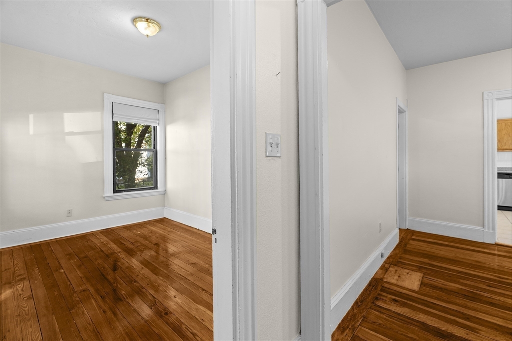 15-17 Cushman Road Boston, MA 02135 - Photo 6 of 27 a view of an empty room with wooden floor and a window