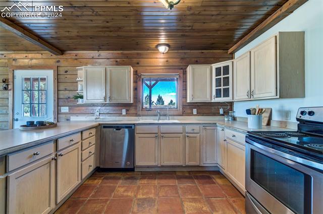 19350 Lemesany Road Calhan, CO 80808 - Photo 20 of 46 Kitchen with wood ceiling, breakfast bar, black fridge, tile floors, dishwasher, and electric stove
