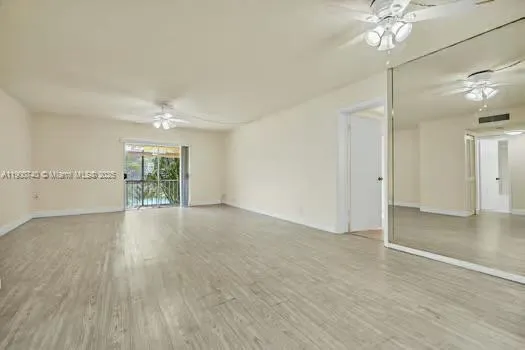 a view of a livingroom with a ceiling fan window wooden floor