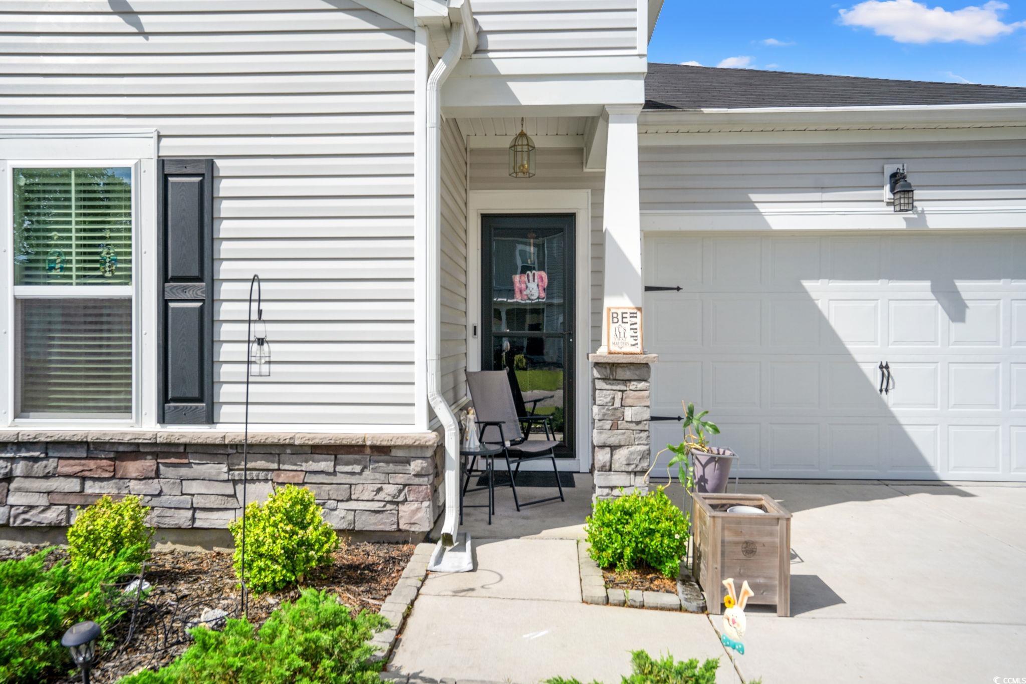 155 Marsh Deer Place Surfside Beach, SC 29575 - Photo 2 of 35 Doorway to property with driveway, a shingled roof, a garage, and stone siding