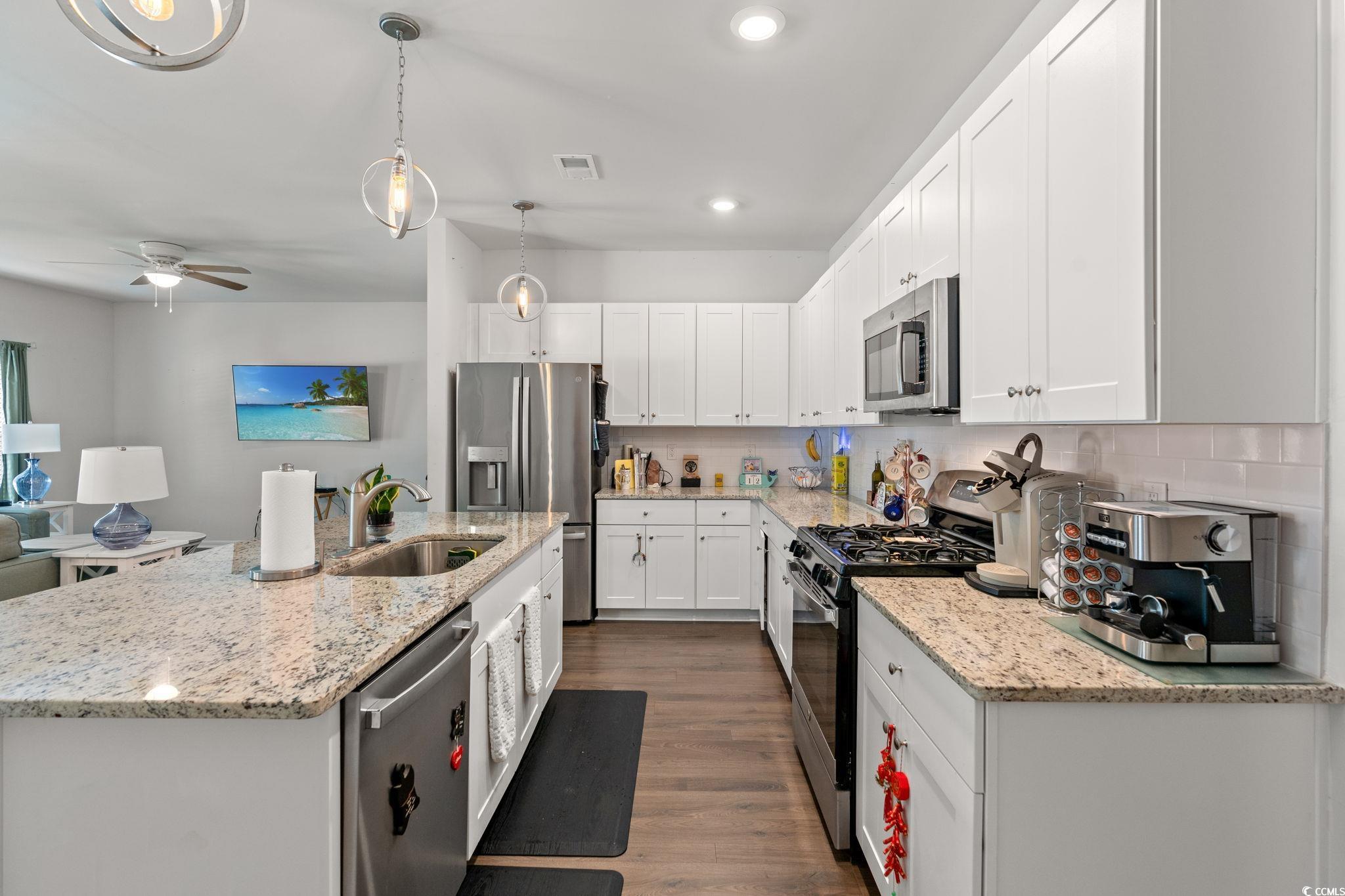 155 Marsh Deer Place Surfside Beach, SC 29575 - Photo 5 of 35 Kitchen with a sink, dark wood-style flooring, a ceiling fan, white cabinetry, and stainless steel appliances