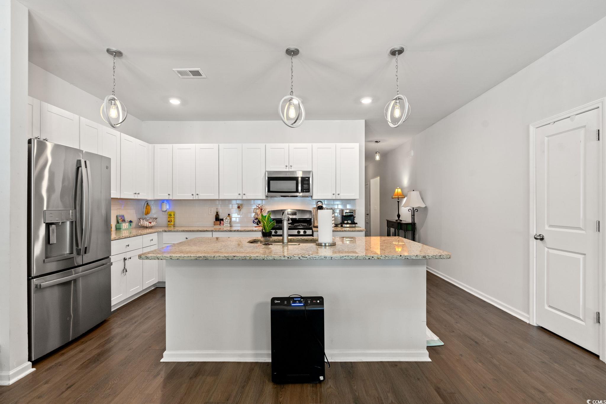 155 Marsh Deer Place Surfside Beach, SC 29575 - Photo 6 of 35 Kitchen with white cabinetry, a kitchen island with sink, visible vents, dark wood finished floors, and appliances with stainless steel finishes