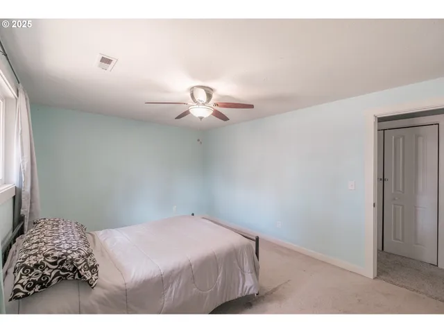 a bedroom with a bed and a chandelier fan