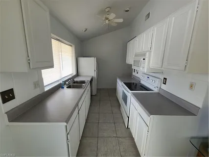 a kitchen with a sink cabinets and a refrigerator