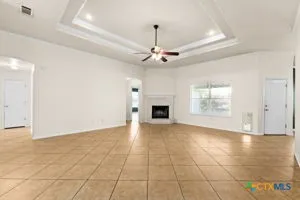 an empty room with windows and fireplace