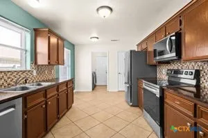a kitchen with stainless steel appliances granite countertop a stove a sink and a microwave