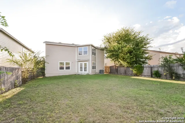 a view of a house with a big yard and large trees