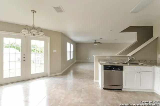 a view of empty room with kitchen and window