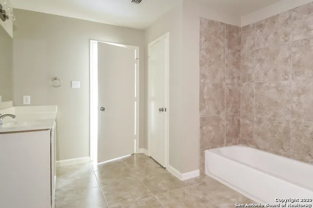 a bathroom with a bathtub a sink a toilet and a mirror