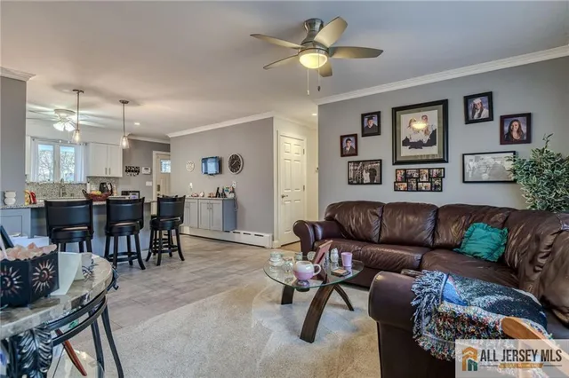 a living room with furniture a dining table and paintings on the wall