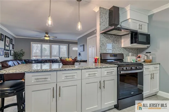 a kitchen with stainless steel appliances granite countertop a sink a stove and cabinets