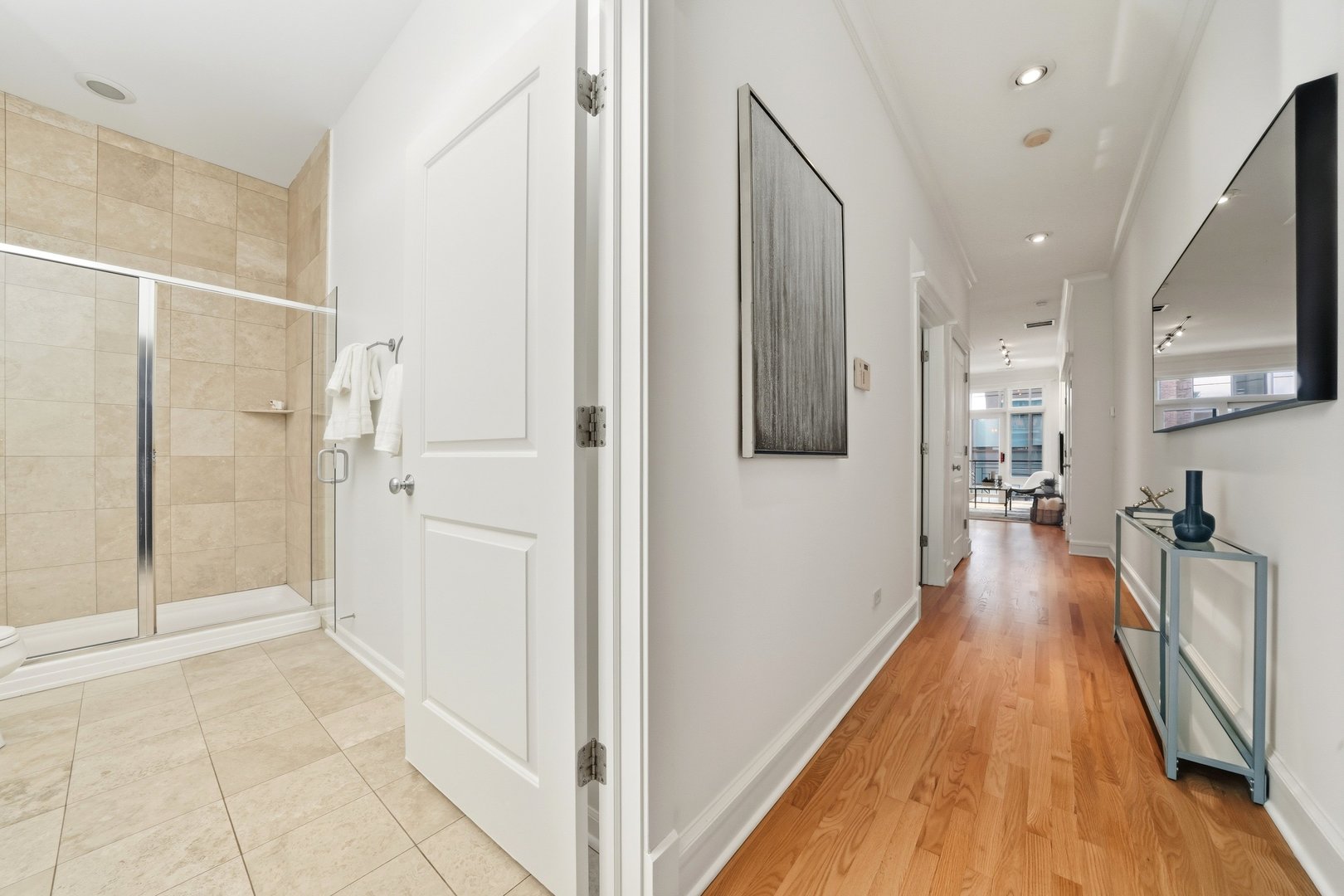 800 West Cornelia Avenue, Unit 307 Chicago, IL 60657 - Photo 7 of 22 a view of a hallway with wooden floor and a bathroom