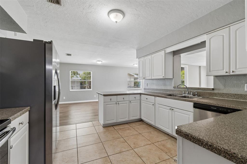 9931 110th Street Seminole, FL 33772 - Photo 15 of 52 a kitchen with a sink window and cabinets