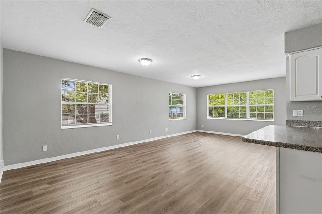 9931 110th Street Seminole, FL 33772 - Photo 17 of 52 a view of an empty room with a window and wooden floor